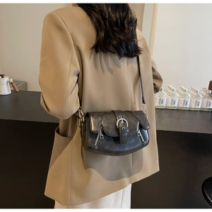 Detail of vintage grey saddle bag showing silver metal ring buckle and zip accents
