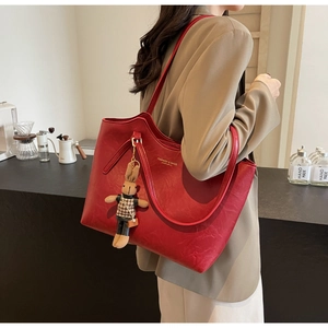 Detail of red tote bag with pleated texture, fashion lettering and rabbit plush charm