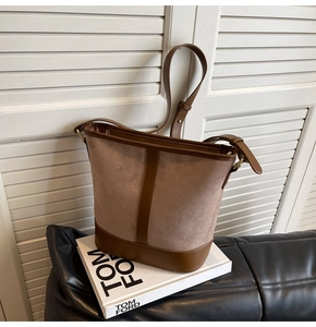 Detail of vintage bucket bag featuring brown suede and smooth leather contrast stitching