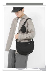 Detail view of black nylon crescent crossbody bag with adjustable strap and mini coin pouch