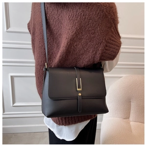 Details einer minimalistischen schwarzen Umhängetasche mit elegantem Gold-Metallverschluss