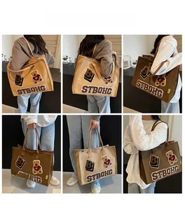Detail view of large canvas tote bag with embroidered bear and letter B patchwork design