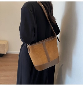 Detailed side view of the brown vintage patchwork bucket bag worn on a model's shoulder
