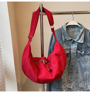 Dettaglio borsa in nylon rosso con design plissettato e fibbia in metallo argento