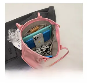 Detailed interior of pink tote bag showing spacious compartments with tablet and wallet