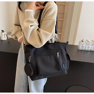 Detail of large black Oxford tote bag with front zipper and removable round coin purse