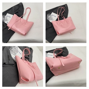 Detail view of pink leather tote bag featuring bottom rivets and strap design