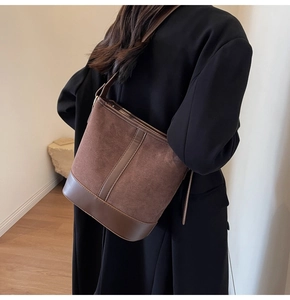Detail of vintage brown patchwork bucket bag with suede texture and smooth leather trim