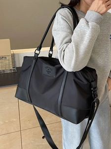 Sac de voyage noir en nylon à grande capacité avec bandoulière réglable et finitions cuir