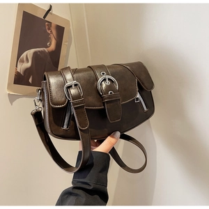 Close-up of vintage dark brown saddle bag featuring double buckles and silver hardware