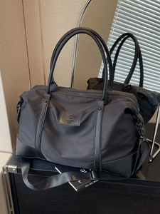 Grand sac de voyage en nylon noir avec poignées renforcées et bandoulière réglable