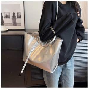 Silver large capacity tote bag with metallic texture and dual handle design shown on shoulder