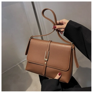 Details der karamellfarbenen Leder-Schultertasche mit Goldschnalle und vertikalem Gurt