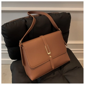 Detailaufnahme der braunen PU-Schultertasche mit goldener Schnalle auf Steppmuster