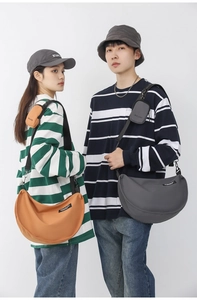Detail of nylon crescent crossbody bags in orange and grey with mini pouch attachment