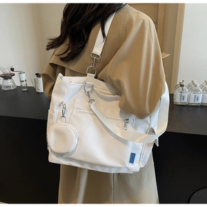 Detail view of large white canvas tote bag with extra mini pouch and adjustable straps