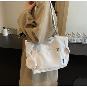 Detailed shot of white Oxford cloth tote bag with matching small coin purse and pockets