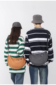 Detail of grey and yellow nylon crossbody bags showing adjustable straps and brand labels