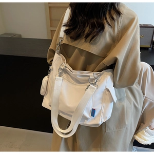 Detail of off-white canvas tote bag with adjustable strap and small round coin purse