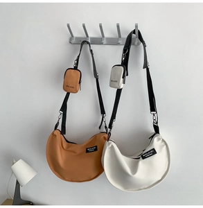 Detail of crescent nylon crossbody bags in brown and white with matching mini pouches
