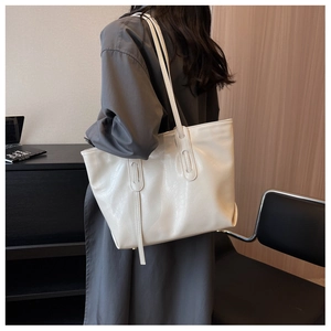 Detailed back view of a large cream PU leather tote bag shown on a model for daily use