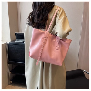 Close-up of pink leather tote bag featuring refined stitching and bottom protective rivets