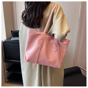 Pink leather tote bag styled on a beige trench coat for a minimalist commuting look