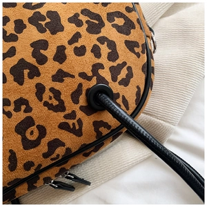 Makro-Detail von Kunstwildleder mit Leopardenmuster und Metallösen an einer Umhängetasche