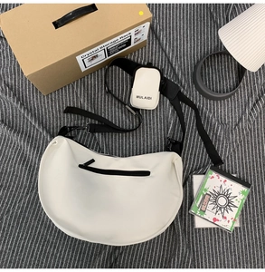 Detail of white nylon crescent bag showing the mini pouch attachment and adjustable strap