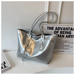 Detail of silver crinkled finish tote bag with metallic texture and thin shoulder straps