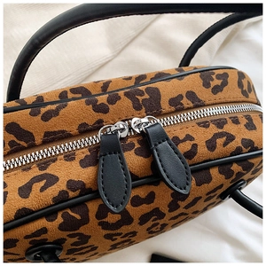Detailaufnahme der Wildledertasche mit Leopardenmuster, Doppelreißverschluss und Ledergriff