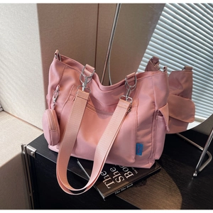 Detail of pink nylon tote bag with multi-pocket design and detachable coin purse