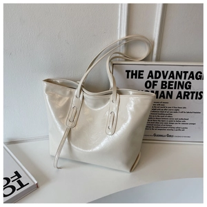 Close-up of cream white tote bag with glossy patent leather and fine wrinkle texture