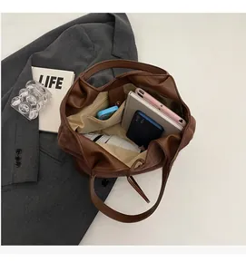 Interior view of brown suede tote bag showing large capacity for laptop and daily items