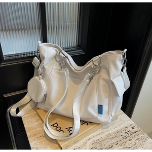 Detail of white canvas tote bag with side pockets and a round zipper pouch attachment