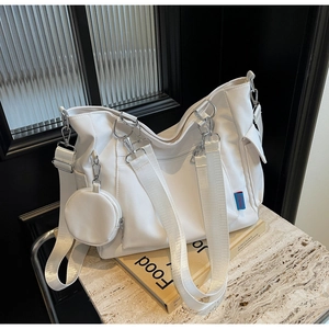 Detail of white canvas tote bag with a matching round coin purse and wide shoulder straps
