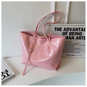 Close-up of pink glossy tote bag showing leather texture and sleek thin shoulder straps