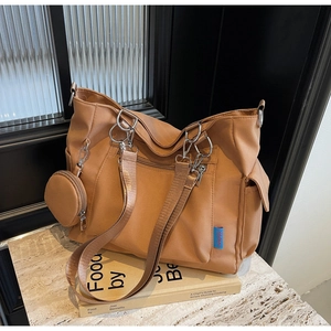 Detail of tan canvas tote bag featuring multi-pocket design and small matching round pouch