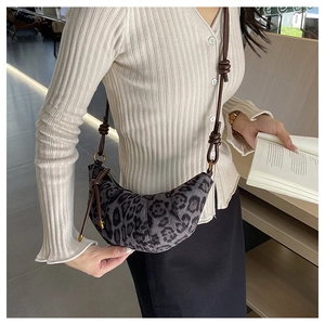 Dettaglio della borsa croissant leopardata con tessuto testurizzato e tracolla scura
