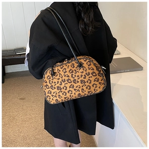 Detailansicht der großen Schultertasche mit Leopardenmuster, getragen von einem Modell