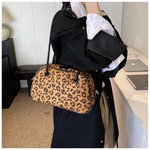 Detailansicht der Schultertasche mit Leopardenmuster, schwarzen Lederriemen und Silberreißverschluss