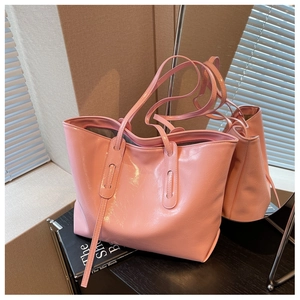 Detail of pink glossy tote bag showing smooth patent finish and slim shoulder straps