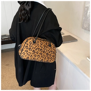 Detailansicht einer stilvollen Umhängetasche mit Leopardenmuster an einem Model