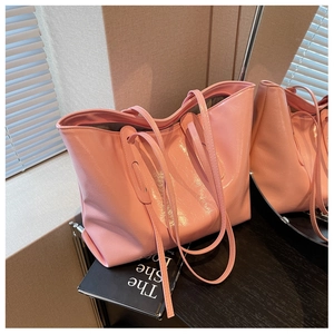 Close-up of pink tote bag featuring a glossy wrinkled texture and sleek handles