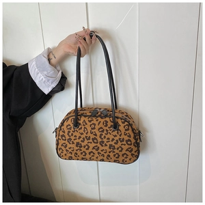 Detail der Handtasche mit Leopardenmuster, Wildlederstruktur und schwarzen Griffen