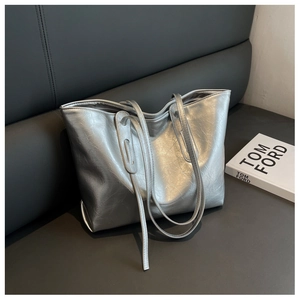 Detail of silver metallic tote bag with wrinkled texture and slender shoulder straps