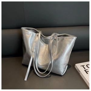 Detail of silver metallic tote bag with stylish pleated texture and long shoulder straps