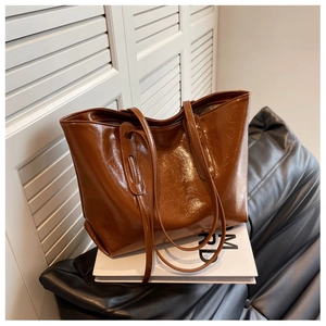 Detail of vintage dark brown wax leather tote bag with natural texture and double straps