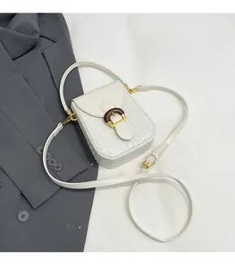Detail of white woven texture crossbody phone bag with gold D-buckle and wooden accents