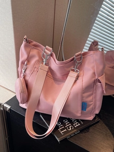 Pink canvas tote bag with wide shoulder strap, zipper pocket and small round coin purse charm